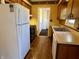 Kitchen featuring white refrigerator, wood cabinets, laminate floors and stainless steel sink at 1031 Schleicher Ave, Indianapolis, IN 46229