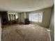 Spacious living room featuring neutral carpet, chair, and a wall of mirrors next to the front door at 1031 Schleicher Ave, Indianapolis, IN 46229