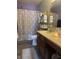 Well-lit bathroom featuring a wooden vanity, toilet, shower with shower curtain and a mirror at 10793 Walnut Grove Bnd, Camby, IN 46113