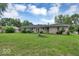Spacious backyard with a lush lawn, ideal for recreation and relaxation, surrounded by mature trees at 120 E Beechwood Ln, Indianapolis, IN 46227