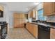 Well-lit kitchen with black appliances, wood cabinets, tile floor, and view to open floorplan at 120 E Beechwood Ln, Indianapolis, IN 46227