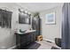 Bathroom features a black vanity with a white countertop, storage cabinet and a decorative macrame wall hanging at 1205 S Dequincy St, Indianapolis, IN 46203