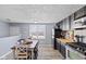 Eat-in dining area with wood-look floors and black cabinets, next to a kitchen with stainless steel appliances at 1205 S Dequincy St, Indianapolis, IN 46203