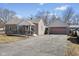 View of a single-story home with a ramp to the front door and a detached garage with a wide driveway at 1205 S Dequincy St, Indianapolis, IN 46203