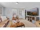 Bright living room featuring a leather sofa, large TV, and an open doorway leading outside at 1205 S Dequincy St, Indianapolis, IN 46203