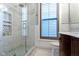 Luxurious bathroom with glass-enclosed shower, marble tile, and a window with privacy shutters at 1471 N Delaware St, Indianapolis, IN 46202