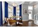 Elegant dining room boasts a chandelier, bay windows with blue curtains, and a modern table set for entertaining at 1471 N Delaware St, Indianapolis, IN 46202
