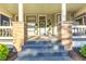 Close-up of a delightful front porch with steps, a wreath on the door, and potted plants at 1471 N Delaware St, Indianapolis, IN 46202