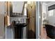 Striking powder room with black pedestal sink, decorative mirror, and elegant wall coverings at 1471 N Delaware St, Indianapolis, IN 46202
