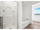 This bathroom features a stylish tub and shower combination with a glass door, enhanced by bright natural lighting at 1585 N Regatta Dr, Greenfield, IN 46140