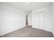 A bright bedroom with neutral carpet, double closet, and a glimpse into the hallway at 1585 N Regatta Dr, Greenfield, IN 46140
