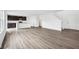 Open concept living space showcasing wood-style flooring and staircase near a modern kitchen at 1585 N Regatta Dr, Greenfield, IN 46140