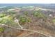 Bird's-eye perspective highlighting the property’s forest setting with houses scattered amid the trees and winding roads at 1794 Bell Rd, Morgantown, IN 46160