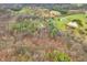 Aerial shot displays a parcel nestled within a dense forest, featuring homes, outbuildings, and a tranquil pond at 1794 Bell Rd, Morgantown, IN 46160