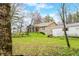 The backyard of the brick home has mature trees and landscaping at 1794 Bell Rd, Morgantown, IN 46160