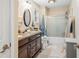 Bathroom featuring double sinks, granite countertops, and a shower-tub combo with glass doors at 1794 Bell Rd, Morgantown, IN 46160