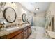 Bathroom featuring double sinks, granite countertops, and a shower-tub combo with glass doors at 1794 Bell Rd, Morgantown, IN 46160