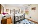Bright bedroom features a wrought iron bed frame, hardwood floors, and large windows with views of blossoming trees at 1794 Bell Rd, Morgantown, IN 46160