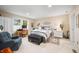 Spacious carpeted bedroom featuring a queen bed, sitting area, and lots of natural light from large windows at 1794 Bell Rd, Morgantown, IN 46160