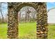 A captivating stone archway frames the picturesque yard of this unique home at 1794 Bell Rd, Morgantown, IN 46160
