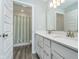 Bright bathroom with double vanity, modern lighting, and an open door view to a separate shower at 19477 Quilling Ln, Noblesville, IN 46062