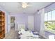 Bright bedroom with lavender walls, three-pane window, carpet flooring, and furniture at 19477 Quilling Ln, Noblesville, IN 46062