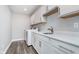 Modern laundry room with white cabinets, quartz countertops, stainless steel sink, and washer and dryer at 19477 Quilling Ln, Noblesville, IN 46062