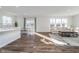 Bright open-concept living room with wood flooring and natural light, seamlessly connecting to the kitchen at 19477 Quilling Ln, Noblesville, IN 46062