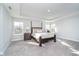 Spacious main bedroom features a king bed, tray ceiling, and plenty of natural light from multiple windows at 19477 Quilling Ln, Noblesville, IN 46062