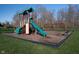 Community playground with a slide, climbing wall, swing set, and safety mulch ground cover at 19477 Quilling Ln, Noblesville, IN 46062