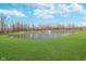 Scenic view of the pond and fountain surrounded by a lush green lawn on a sunny day at 19477 Quilling Ln, Noblesville, IN 46062
