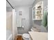 Gray bathroom featuring a tub with shower, a toilet, and a storage cabinet at 2305 Bill Smith Rd, Martinsville, IN 46151