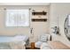 A cozy bedroom featuring soft chair seating, natural lighting, wall shelves, and stylish decor at 2305 Bill Smith Rd, Martinsville, IN 46151