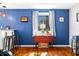 Dining area featuring vibrant blue walls, a hardwood floor, a drop-leaf table, and bar seating adding a touch of elegance at 2305 Bill Smith Rd, Martinsville, IN 46151