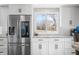 Kitchen boasts stainless steel refrigerator, white cabinets, granite countertops, and a bright window at 2305 Bill Smith Rd, Martinsville, IN 46151