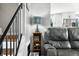Living room with a cozy gray leather reclining sofa, a decorative lamp, and a staircase to an upper level of the house at 2305 Bill Smith Rd, Martinsville, IN 46151