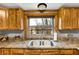 Close up of the kitchen sink featuring wood cabinets and large window for natural lighting at 2387 Bill Smith Rd, Martinsville, IN 46151