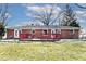 Expansive backyard view showing red-railed patio deck surrounded by a green lawn at 244 Corottoman Ct, Avon, IN 46123