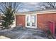 A small concrete patio features double doors exiting the brick house; small green lawn at 244 Corottoman Ct, Avon, IN 46123