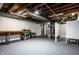 Unfinished basement space with white painted walls, a utility area, and ample room for storage or projects at 2615 Kessler Blvd E Dr, Indianapolis, IN 46220