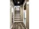 Staircase leading to the basement with wood laminate floors in the hallway at 2615 Kessler Blvd E Dr, Indianapolis, IN 46220