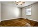 Cozy bedroom with hardwood floors, a ceiling fan, and a single window for natural lighting at 2615 Kessler Blvd E Dr, Indianapolis, IN 46220