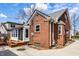 Brick house exterior with sunroom, landscaped yard, and charming architectural details at 2615 Kessler Blvd E Dr, Indianapolis, IN 46220