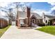 Inviting brick home with a long driveway, lush green lawn, and mature trees at 2615 Kessler Blvd E Dr, Indianapolis, IN 46220