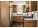 Well-lit kitchen showcasing wooden cabinetry, stainless steel appliances, and white subway tile backsplash at 2615 Kessler Blvd E Dr, Indianapolis, IN 46220