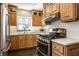 Updated kitchen showing wood cabinets, white counters, stainless appliances, and tile backsplash at 2615 Kessler Blvd E Dr, Indianapolis, IN 46220