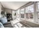 Light-filled sunroom with cozy furniture, large windows, and access to outdoor deck at 2615 Kessler Blvd E Dr, Indianapolis, IN 46220