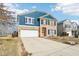 Inviting two-story home featuring brick and blue siding, a two-car garage, and a neatly landscaped front yard at 3132 W Meadowbend Dr, Monrovia, IN 46157