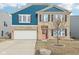Inviting two-story home featuring brick and blue siding, a two-car garage, and a neatly landscaped front yard at 3132 W Meadowbend Dr, Monrovia, IN 46157