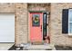 Charming brick entryway with a bright coral door, decorative wreath, and a welcoming checkered doormat at 3132 W Meadowbend Dr, Monrovia, IN 46157